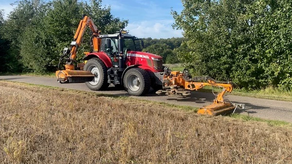 Billede af en traktor med græsklípper monteret foran og bagpå