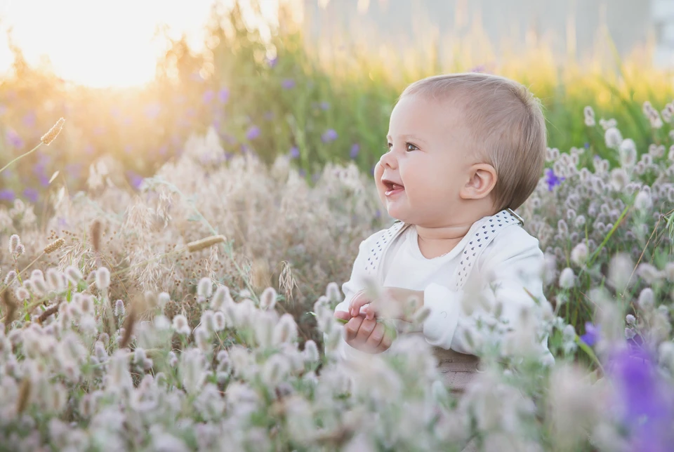 Baby sidder i græsset 