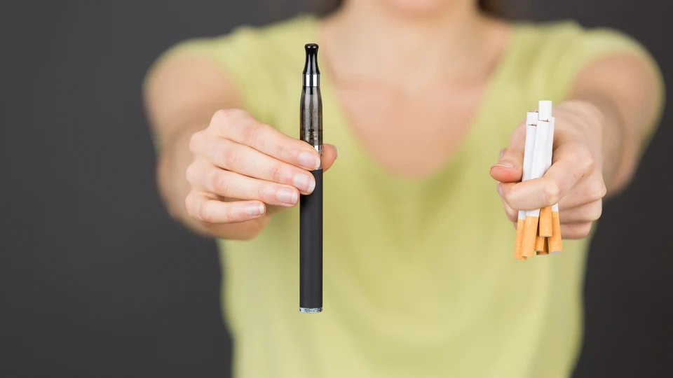 Kvinde der holder en vape og cigaretter