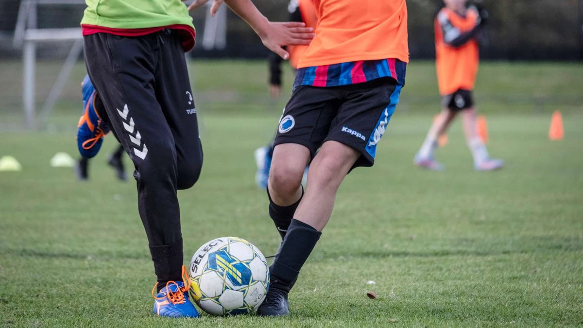 Drenge i løb, der spiller fodbold