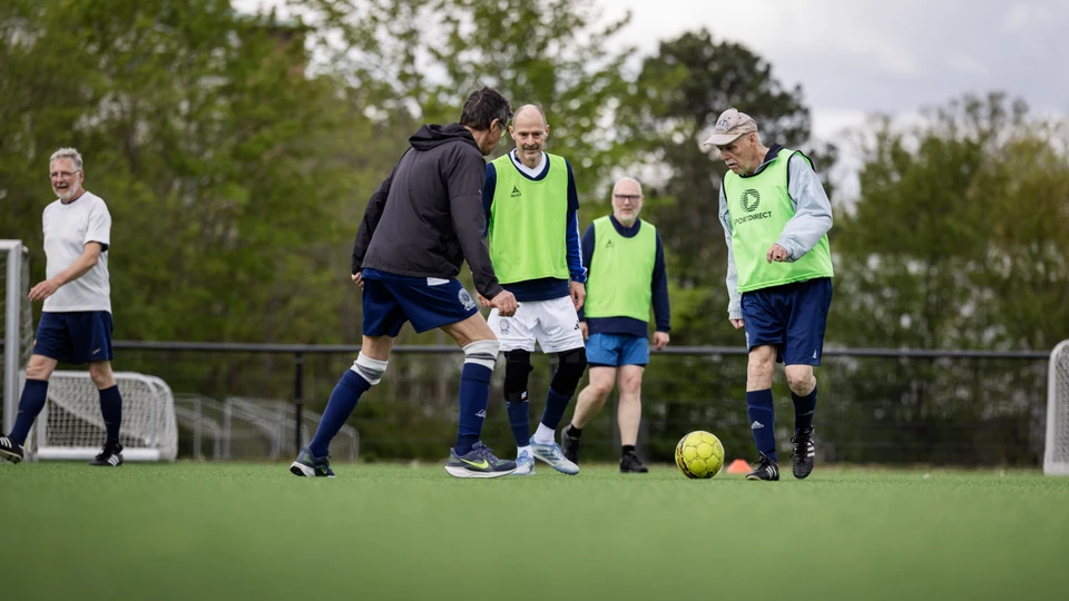 Billede af en gruppe ældre mænd, der spiller fodbold