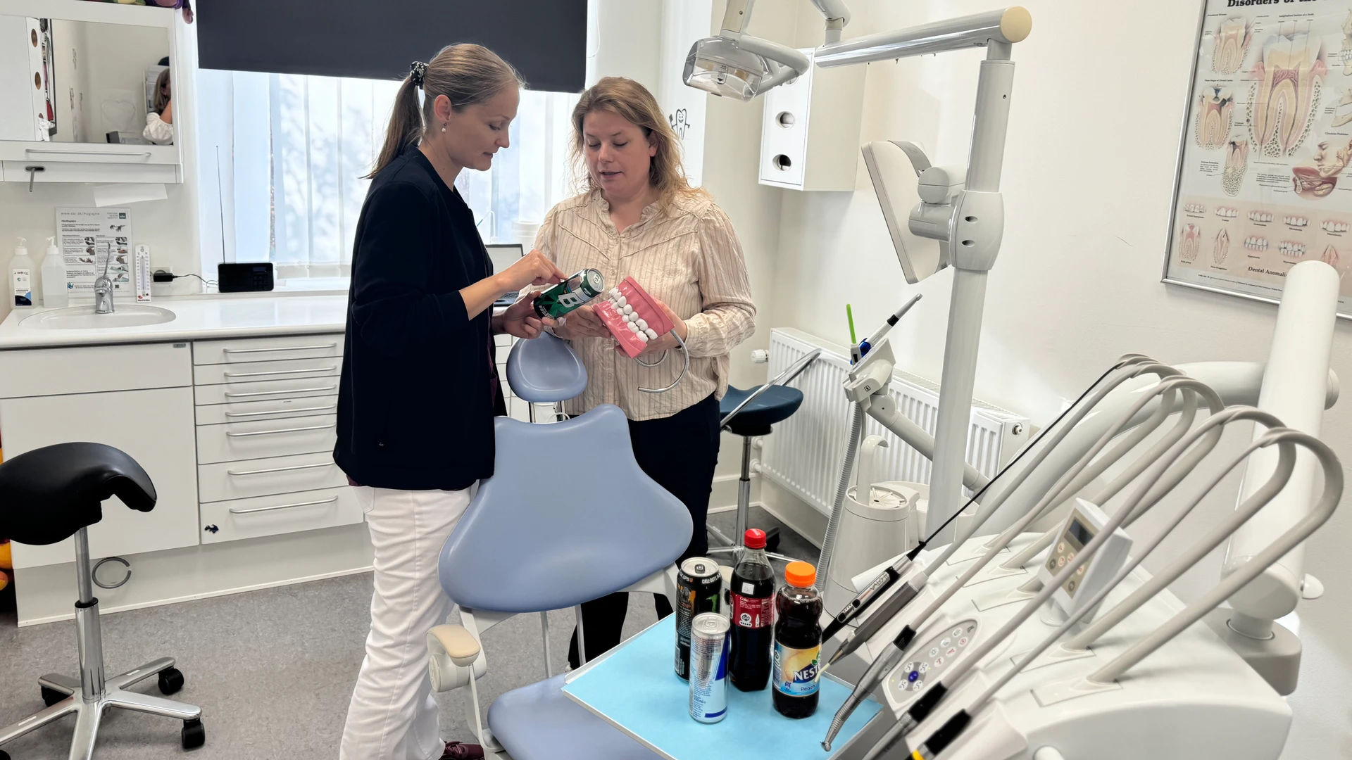 To mennesker i en tandlægeklinik kigger på indholdet i en energidrik